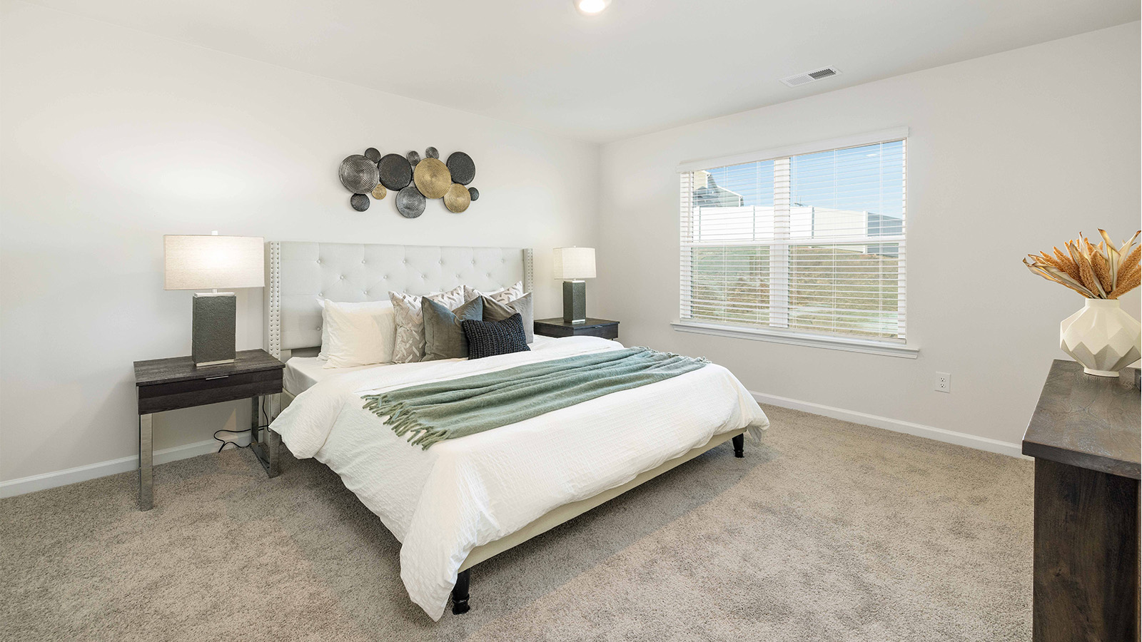 Primary carpeted bedroom with windows