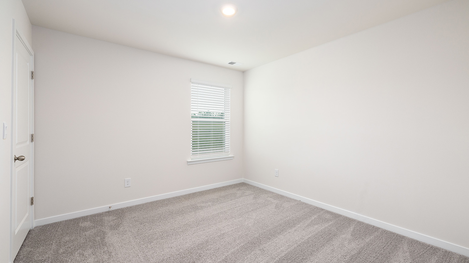 Carpeted bedroom with large window, view of bathroom door
