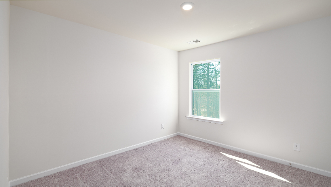 Carpeted bedroom  with small window