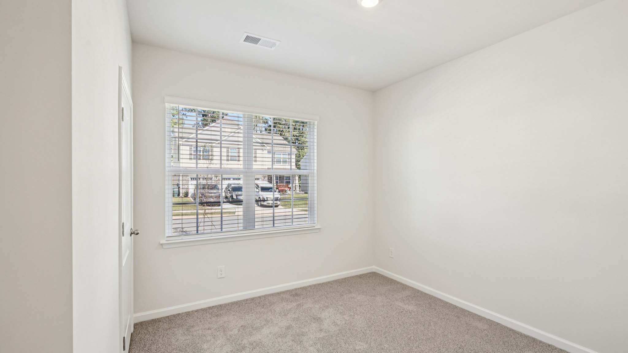 Carpeted bedroom with windows