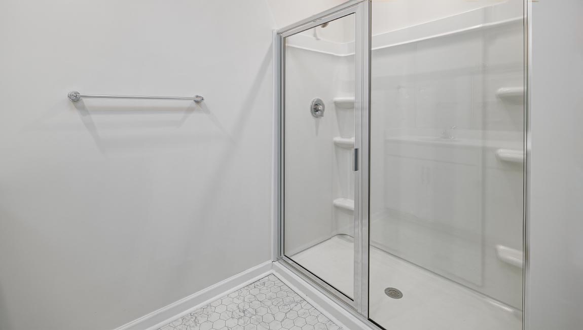 Primary bathroom with double sinks and standing glass shower