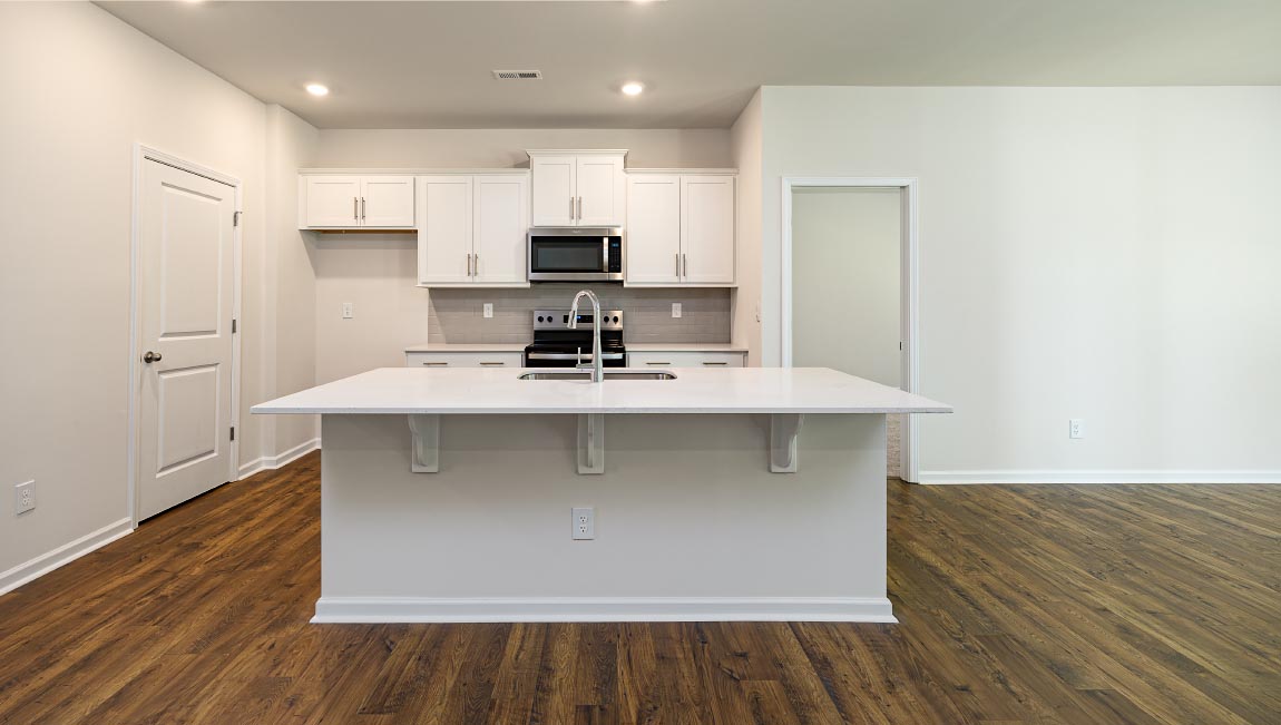 Kitchen and island with white cabinets and subway tiles and stainless steel subway tiles