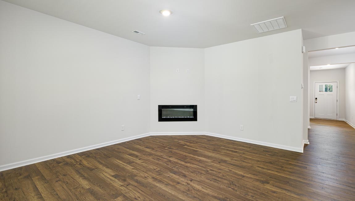 Open living room with wood floors, large window, and fireplace