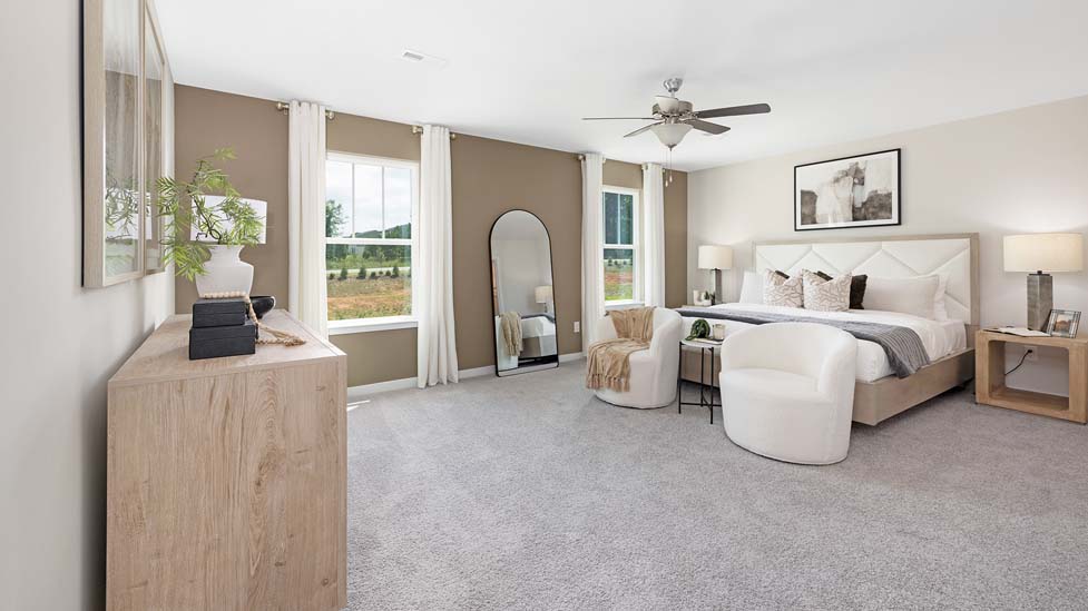 Primary bedroom with carpet and two large windows