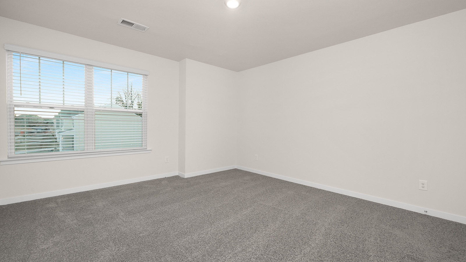 Carpeted bedroom with large windows