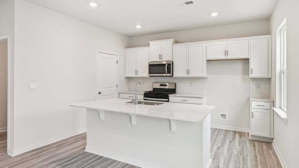 Kitchen and island with stainless steel appliances