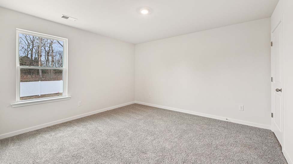 Carpeted bedroom with large windows