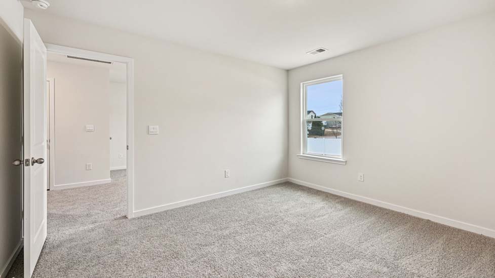 Carpeted bedroom with large windows