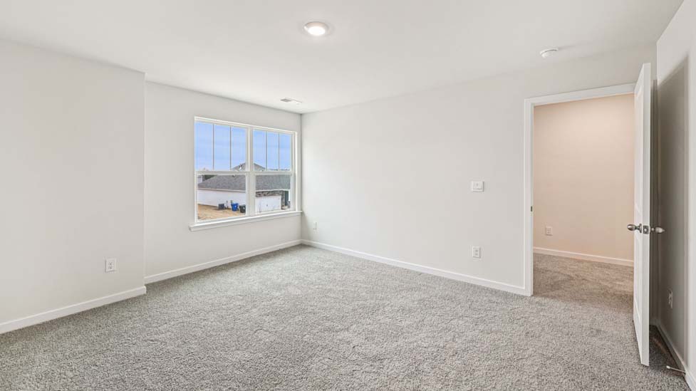 Carpeted bedroom with large windows