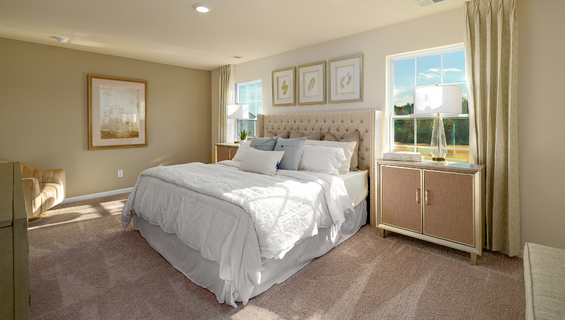 Primary bedroom, carpeted with two large windows