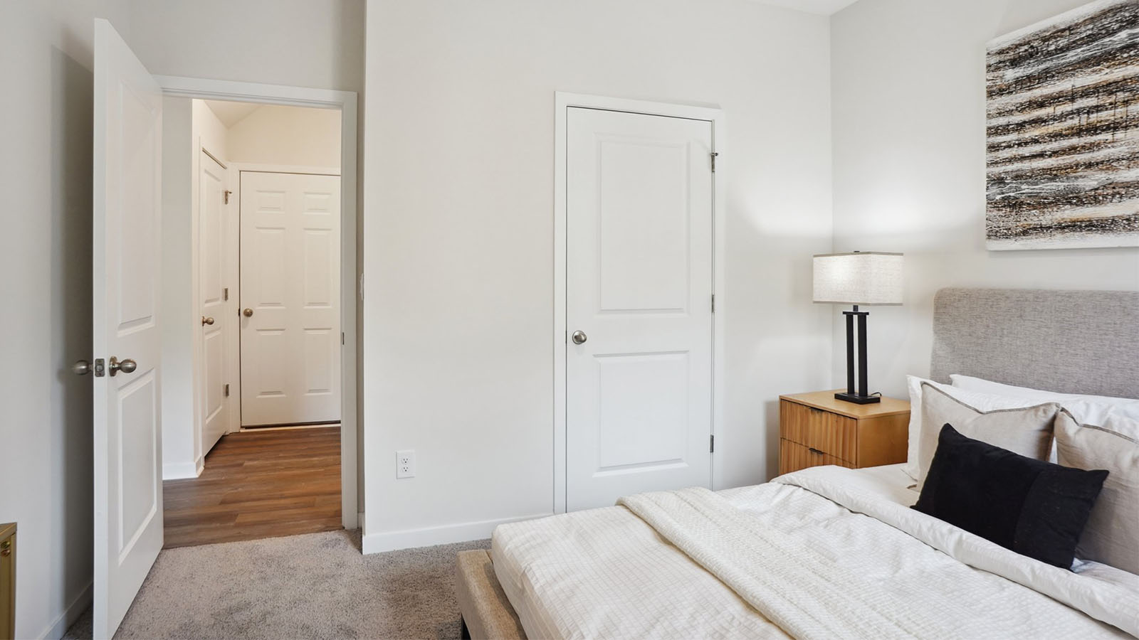 Model primary carpeted bedroom with large window