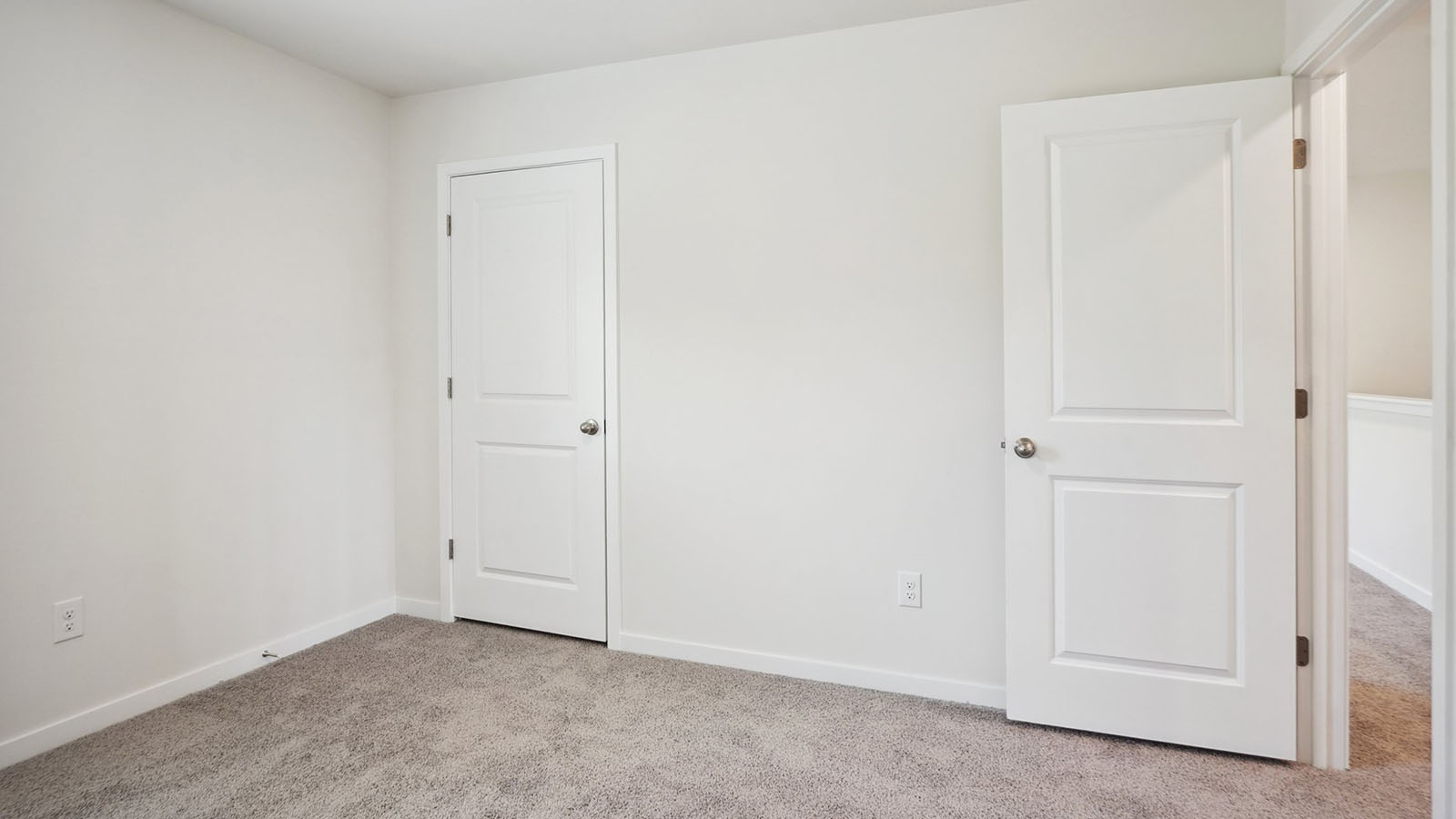 Model carpeted bedroom with small window