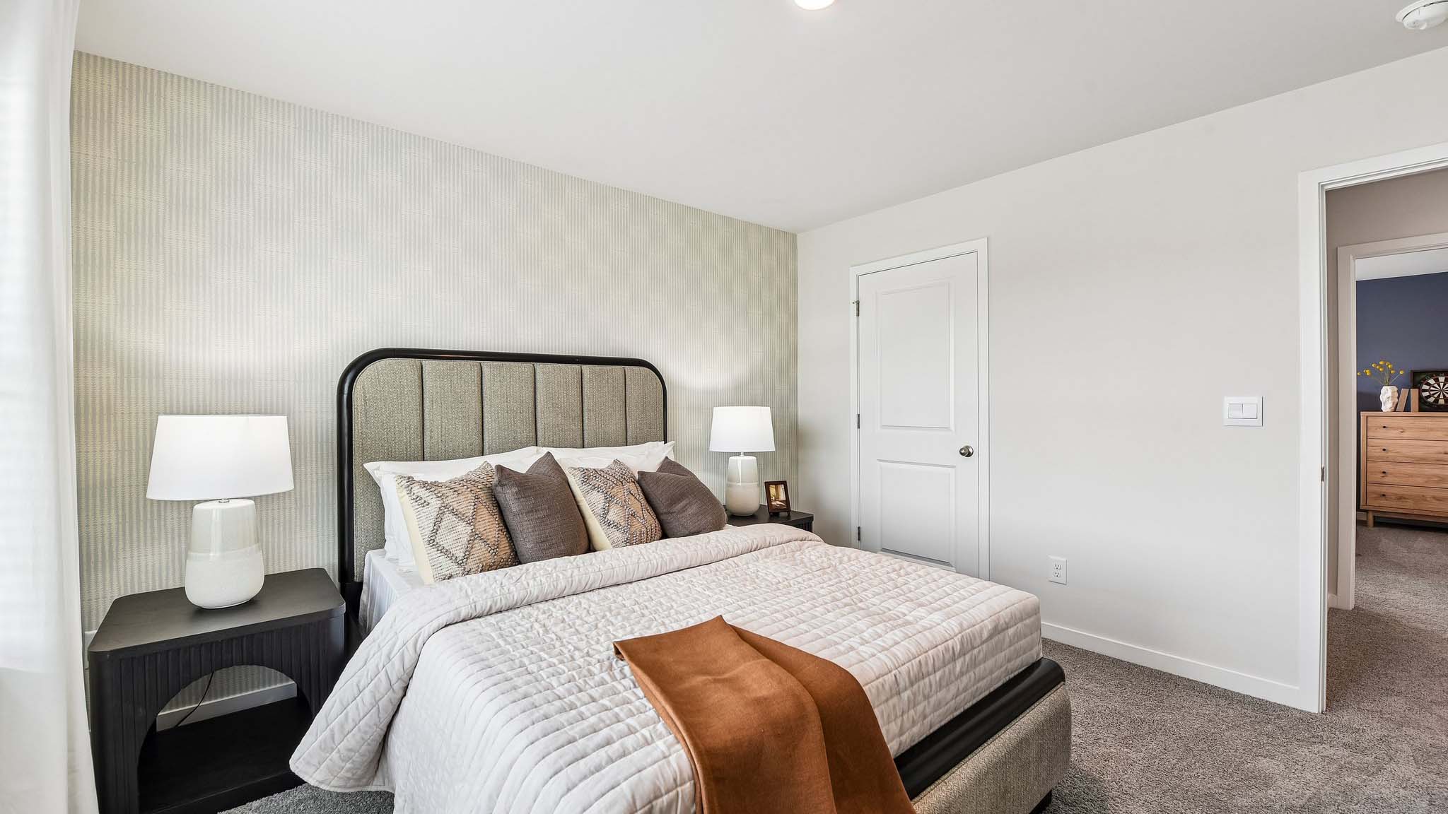 Carpeted bedroom with large window, view of bathroom door