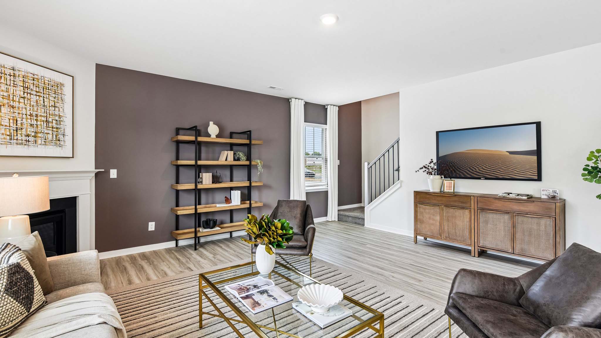 Living room space with wood floors, three large windows