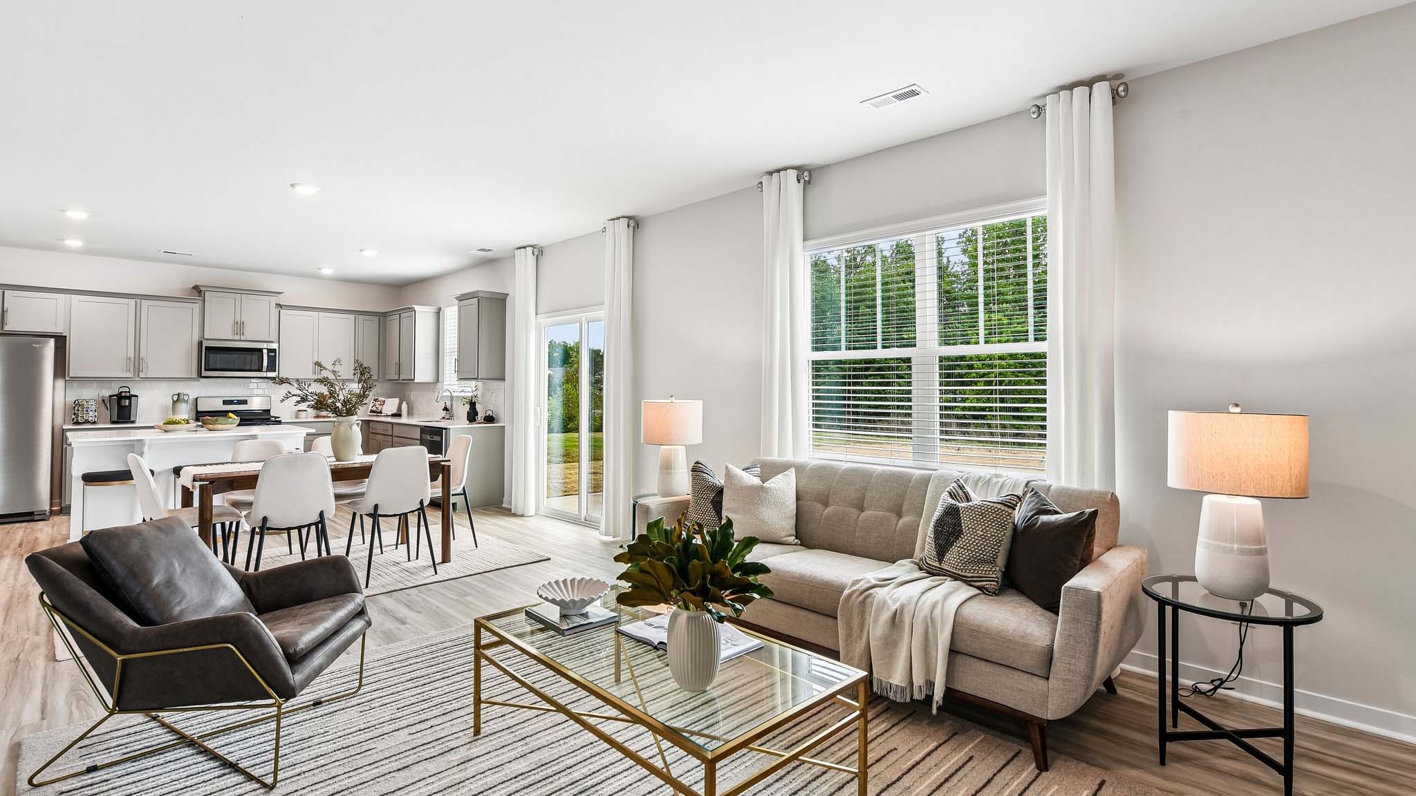 Living room space with wood floors, three large windows