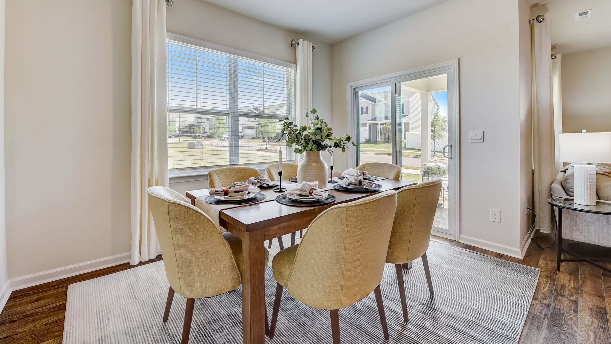 Dining room with wood floors, large window and sliding glass back door
