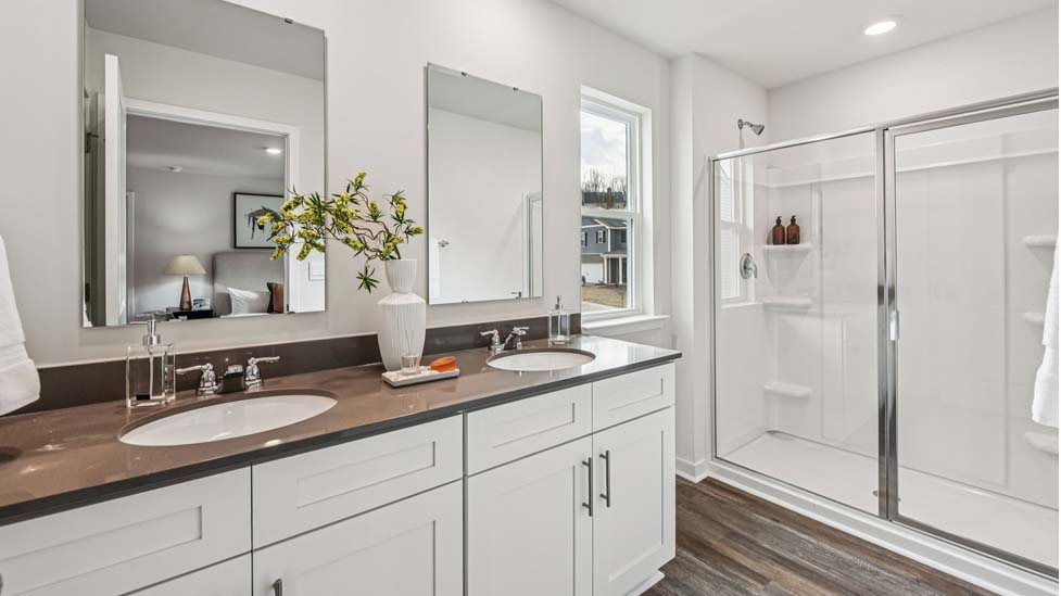 Primary bathroom with double sink vanity and standing shower