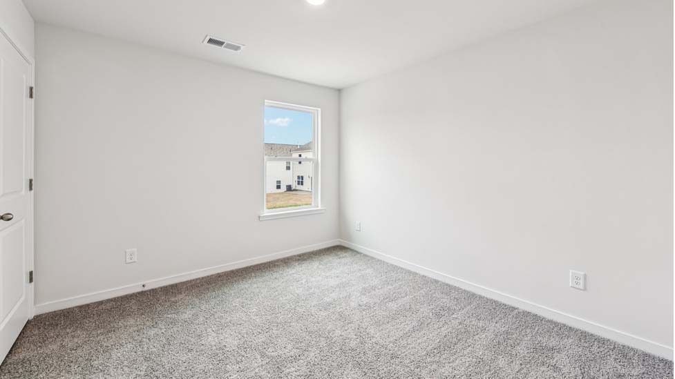 Carpeted bedroom with small window