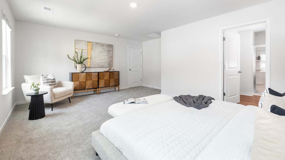 Primary bedroom with carpet and two large windows