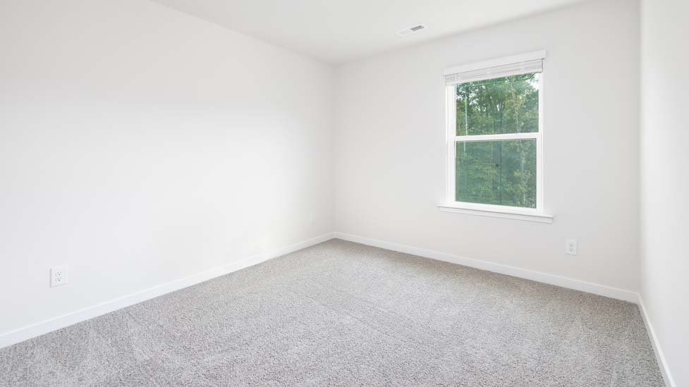 Carpeted bedroom with large window