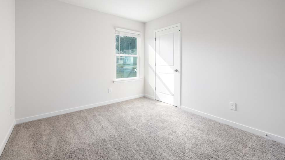 Carpeted bedroom with large window