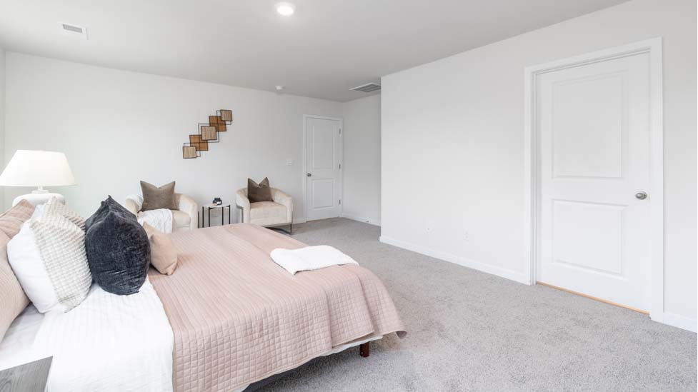 Primary bedroom with carpet and two large windows