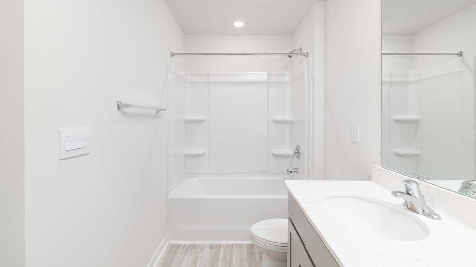 Bathroom with double sink vanity, white counters and cabinets, standing glass door shower