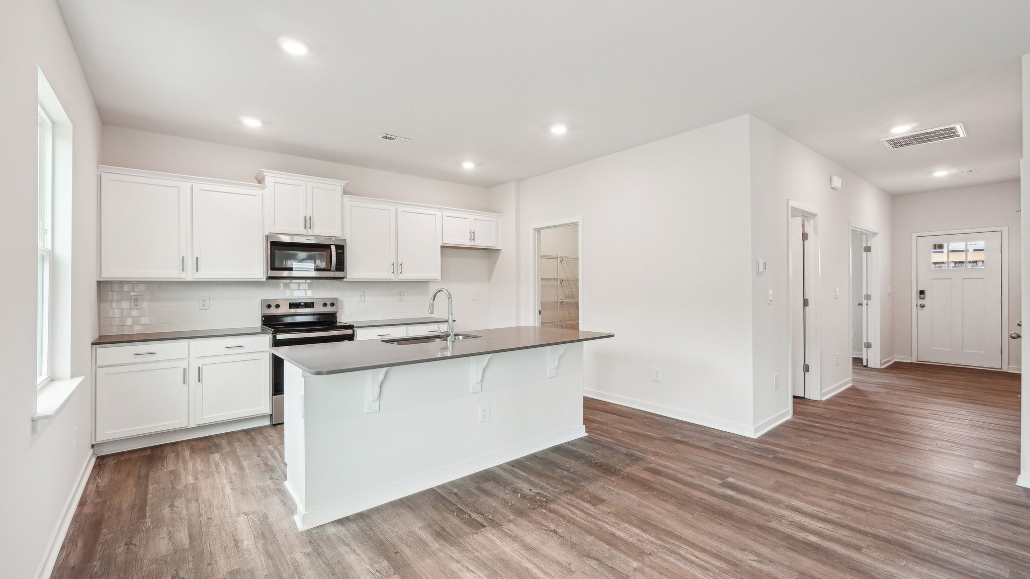 kitchen and island with large window and stainless steel appliances