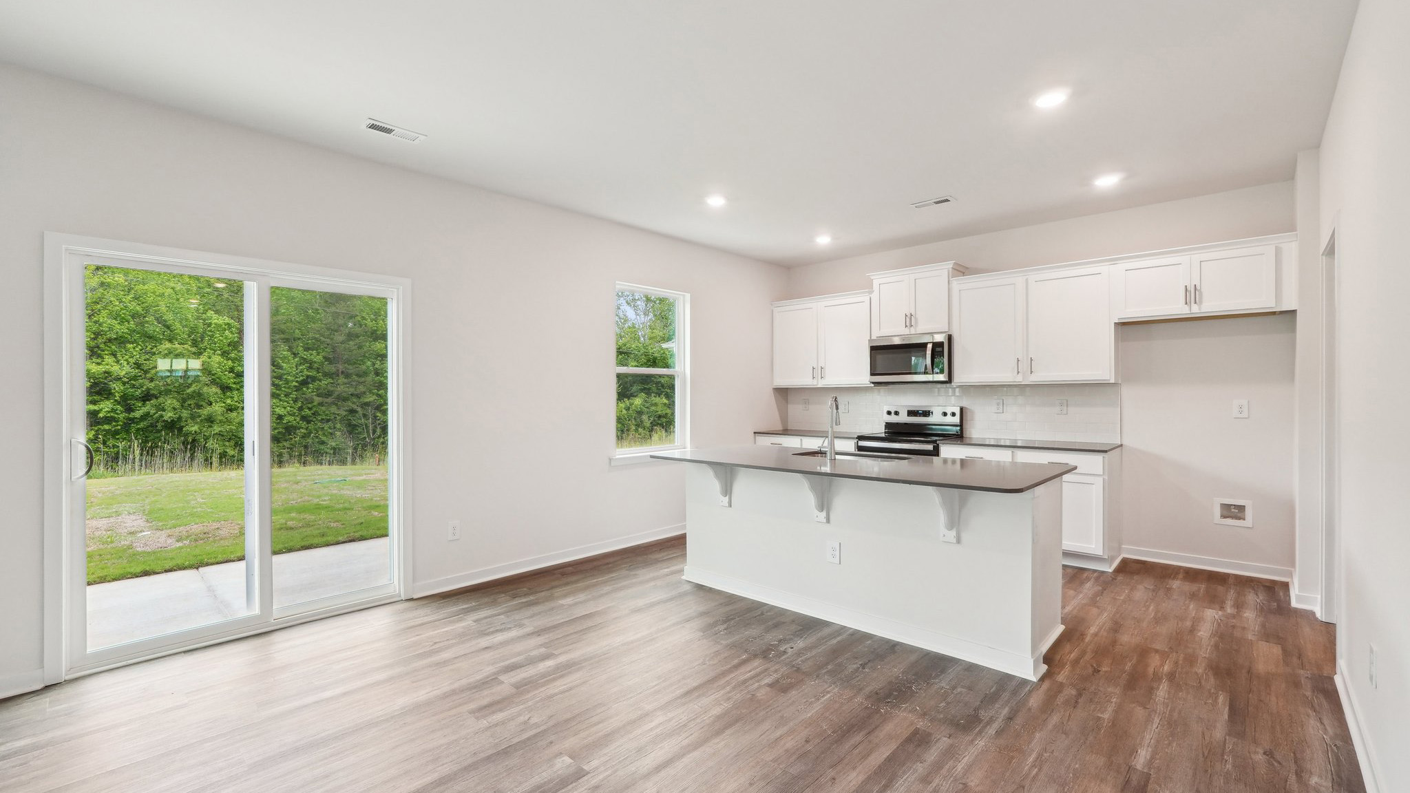 kitchen and island with large window and stainless steel appliances