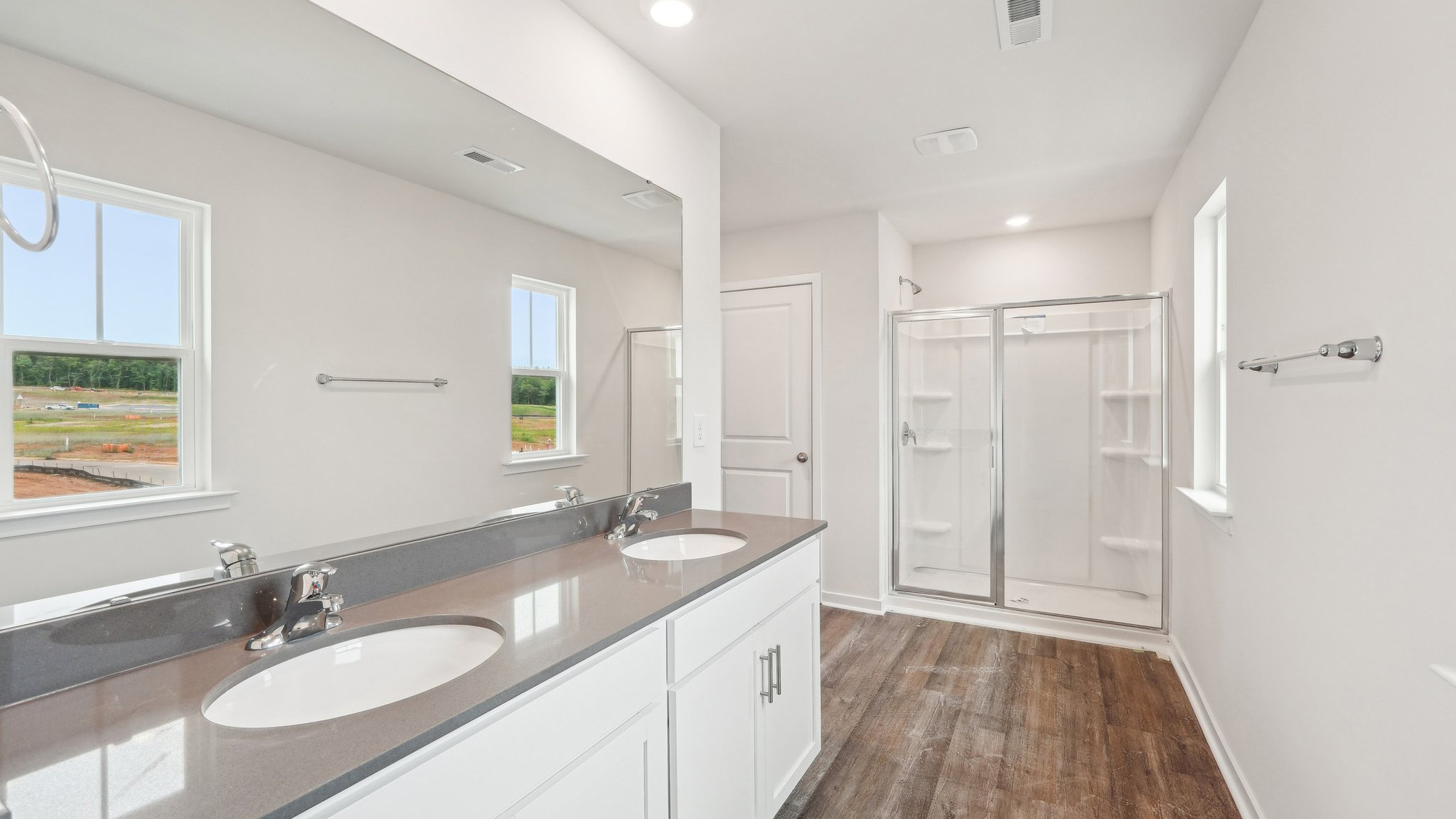 primary bathroom with standing shower and double sink vanity