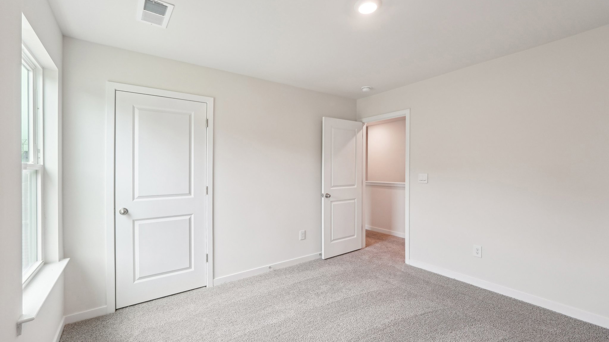 Carpeted bedroom with windows