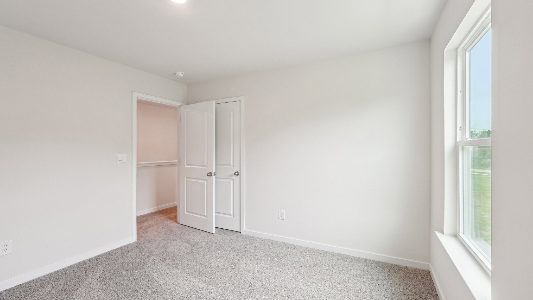 Carpeted bedroom with windows