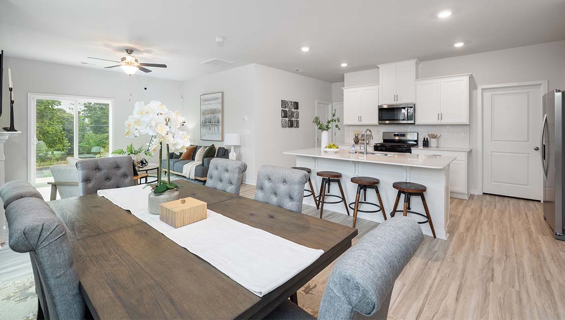 Kitchen and island with white cabinets and wood flooring
