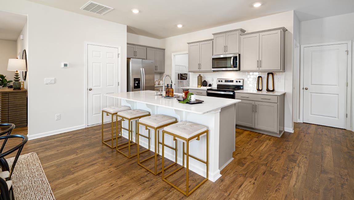 Kitchen and island with white cabinets and wood flooring