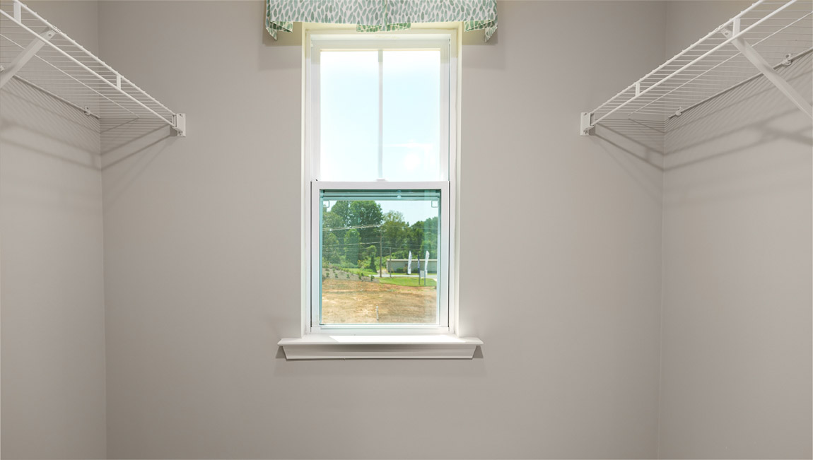 Model primary carpeted walk in closet