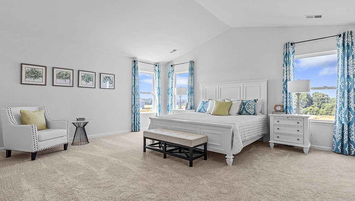 Primary carpeted bedroom with large windows