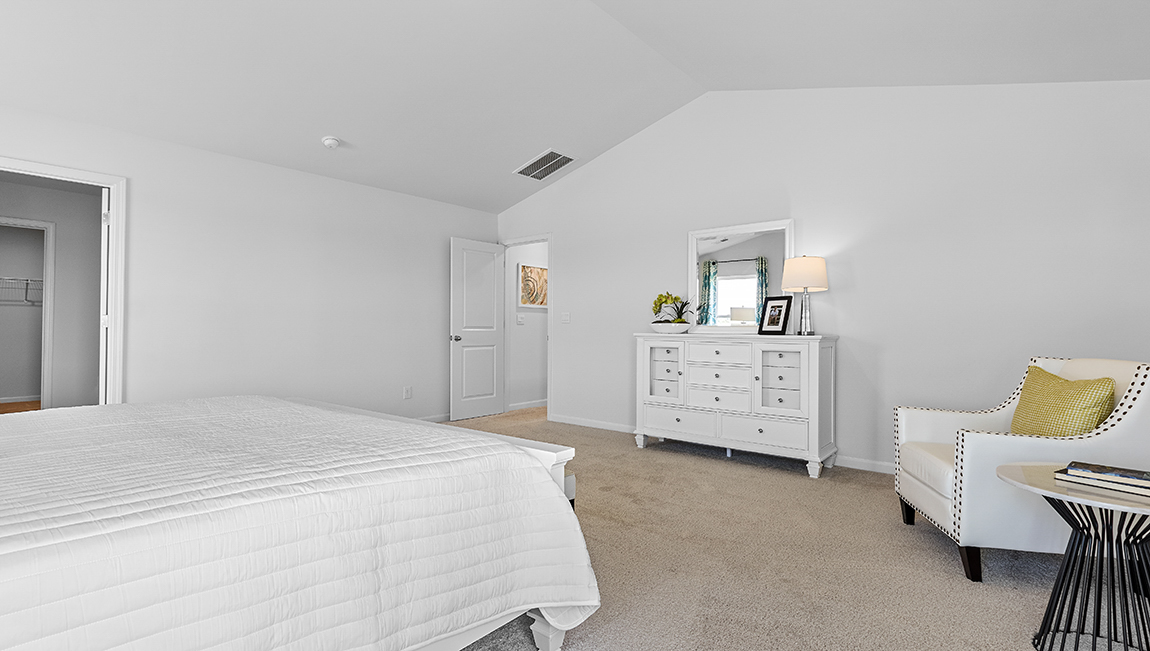 Primary carpeted bedroom with large windows