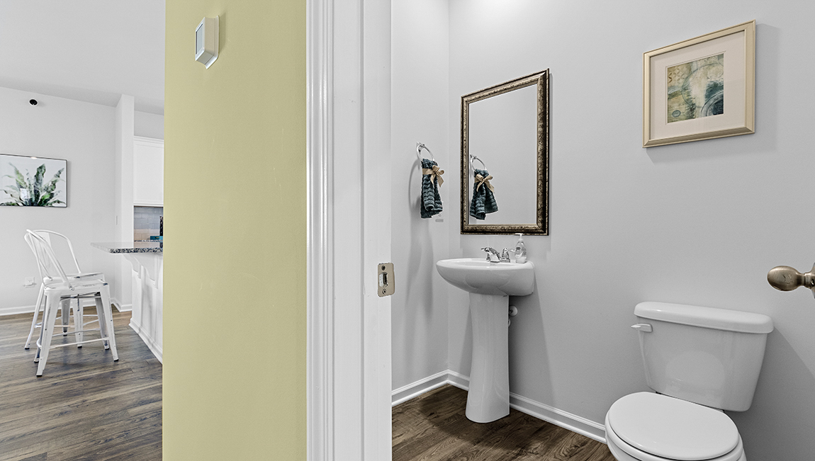 Bathroom with double sinks, bathtub, and white cabinets and counters