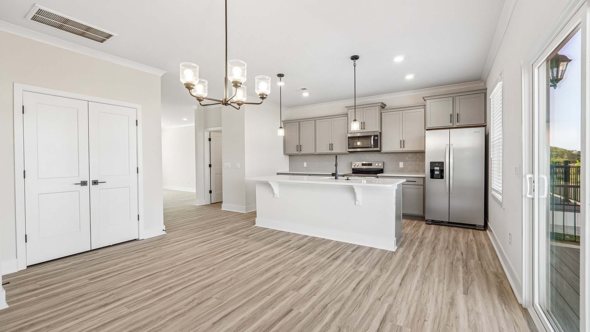 Kitchen and island with white counters and stainless steel appliances