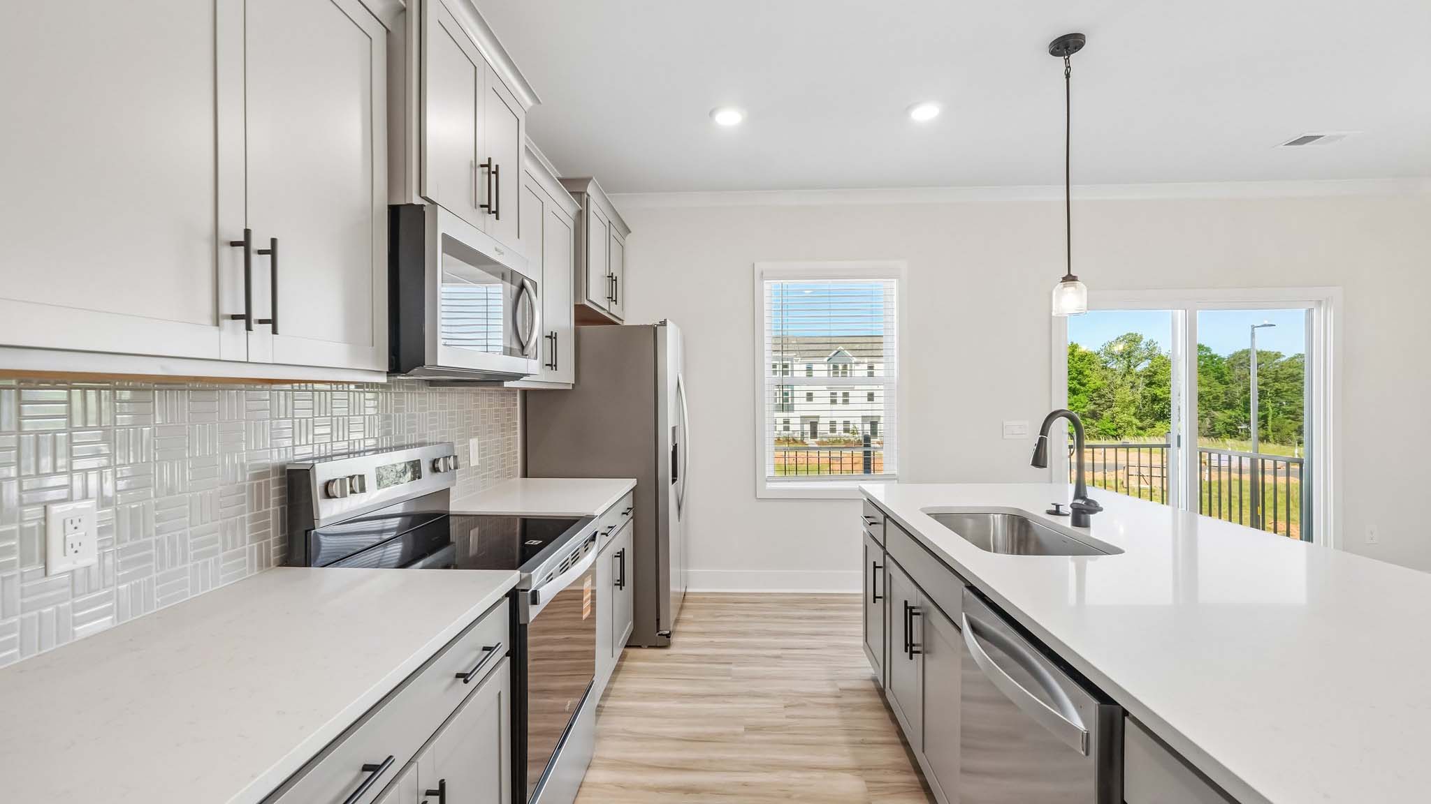 Kitchen and island with white counters and stainless steel appliances