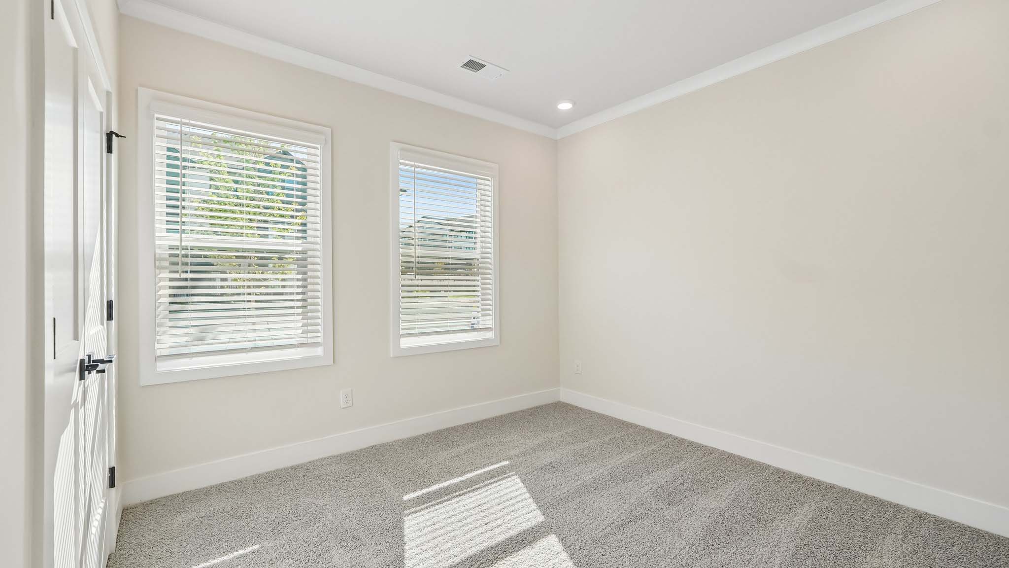 Carpeted bedroom with windows