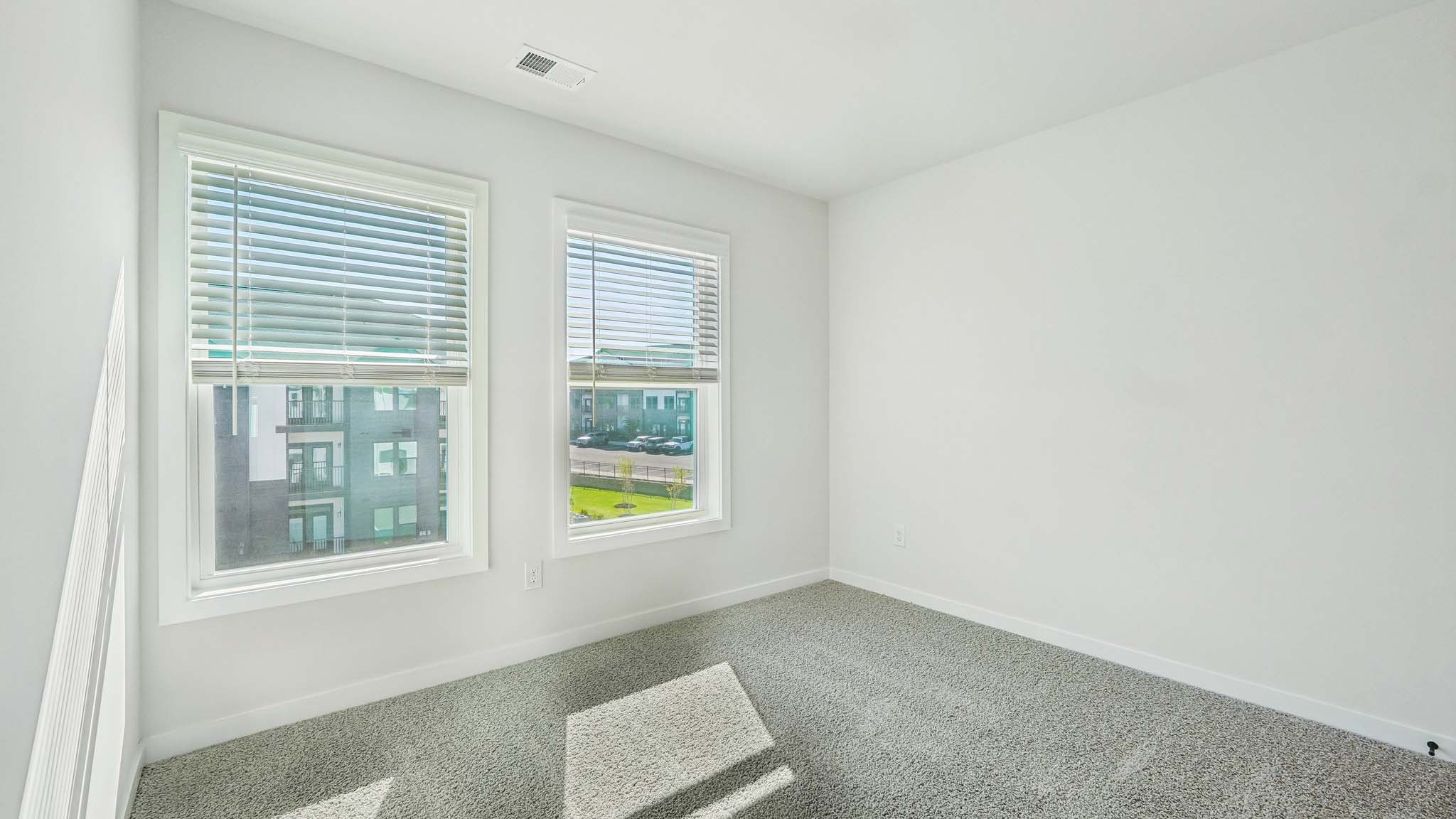 Carpeted bedroom with windows