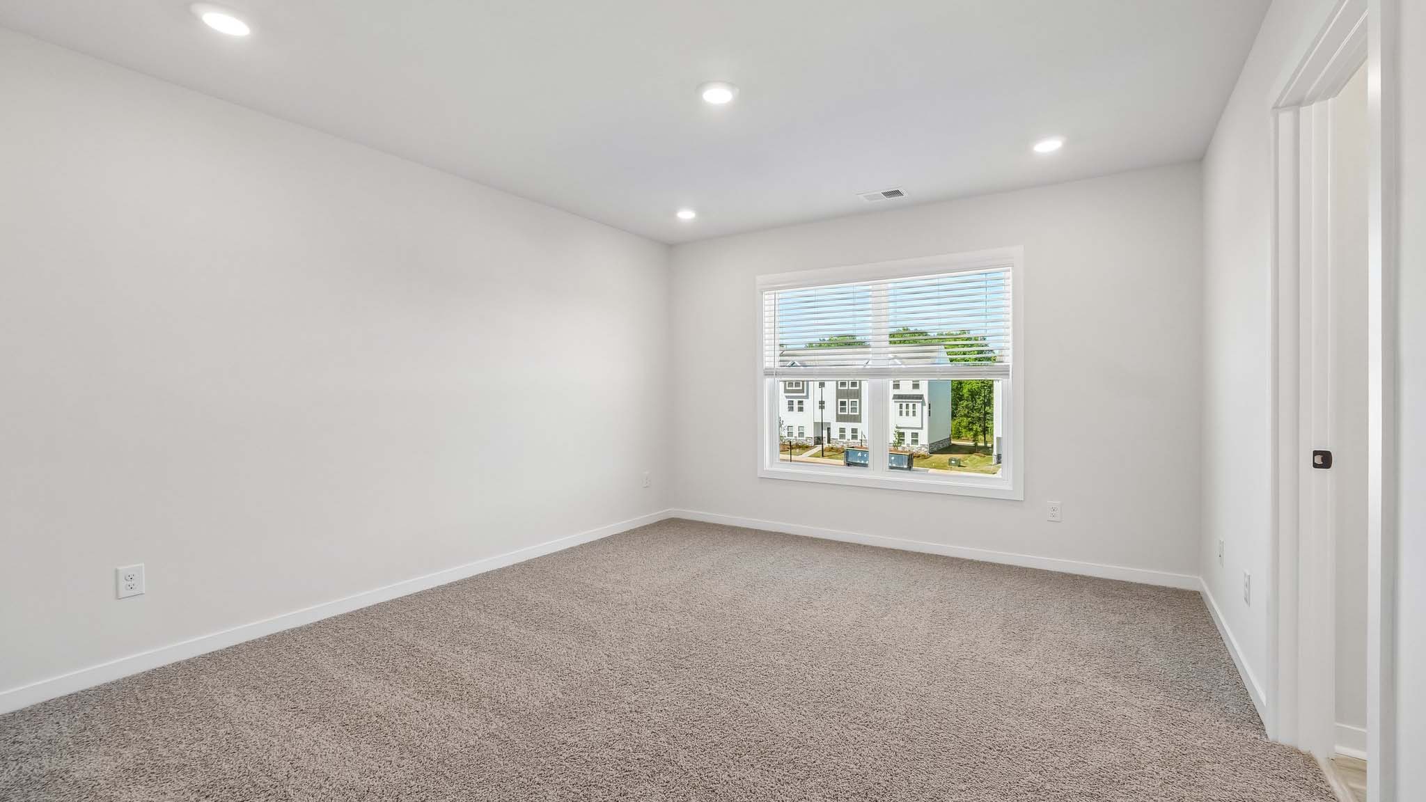 Carpeted bedroom with windows