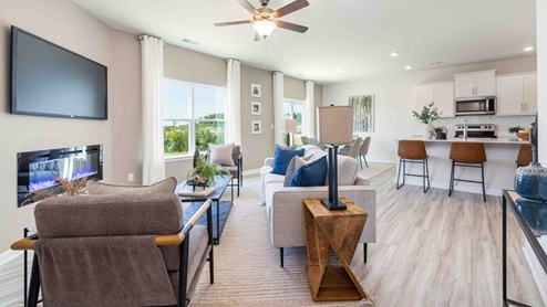 Open living room beside kitchen and dining with electric fireplace and large window