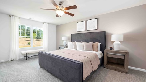 Primary bedroom with beige carpet, ceiling fan and large window