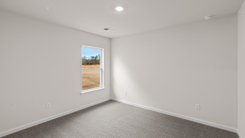 carpeted bedroom with small window