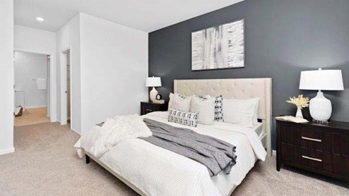 Carpeted bedroom with view of hall to closet and bathroom
