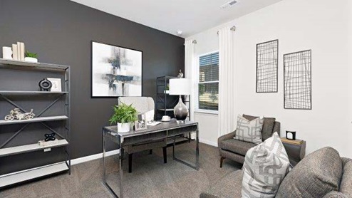 Carpeted bedroom with small window, being used as an office