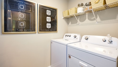 Model laundry room with rack above machines