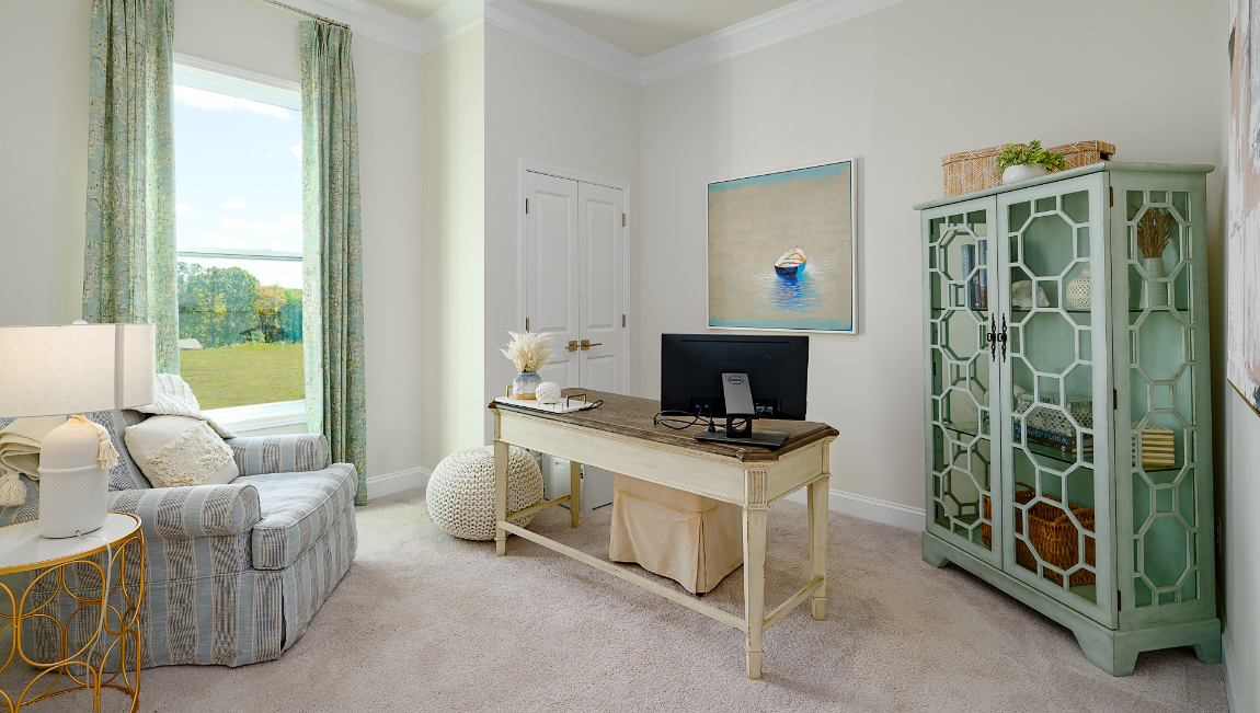 Carpeted bedroom with large window, being used as an office